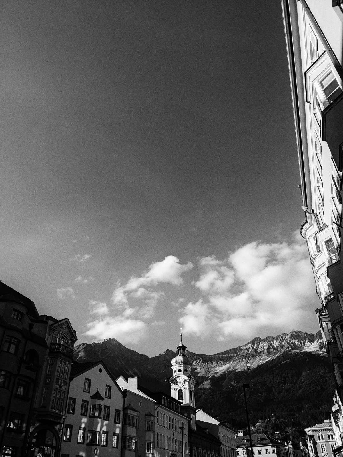 Black-and-white view of Innsbruck old town with mountains behind