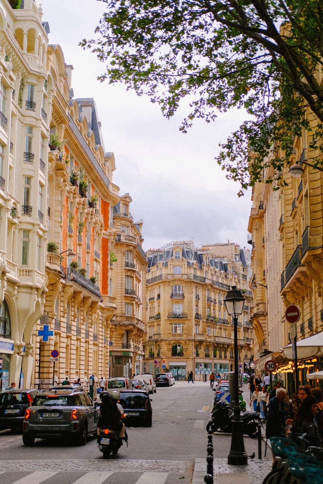 Paris street lined with multistorey facades and pedestrians
