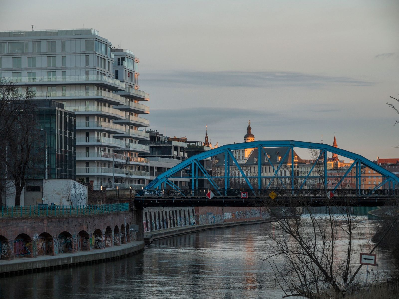Blue steel bridge over a river channel in Wrocław