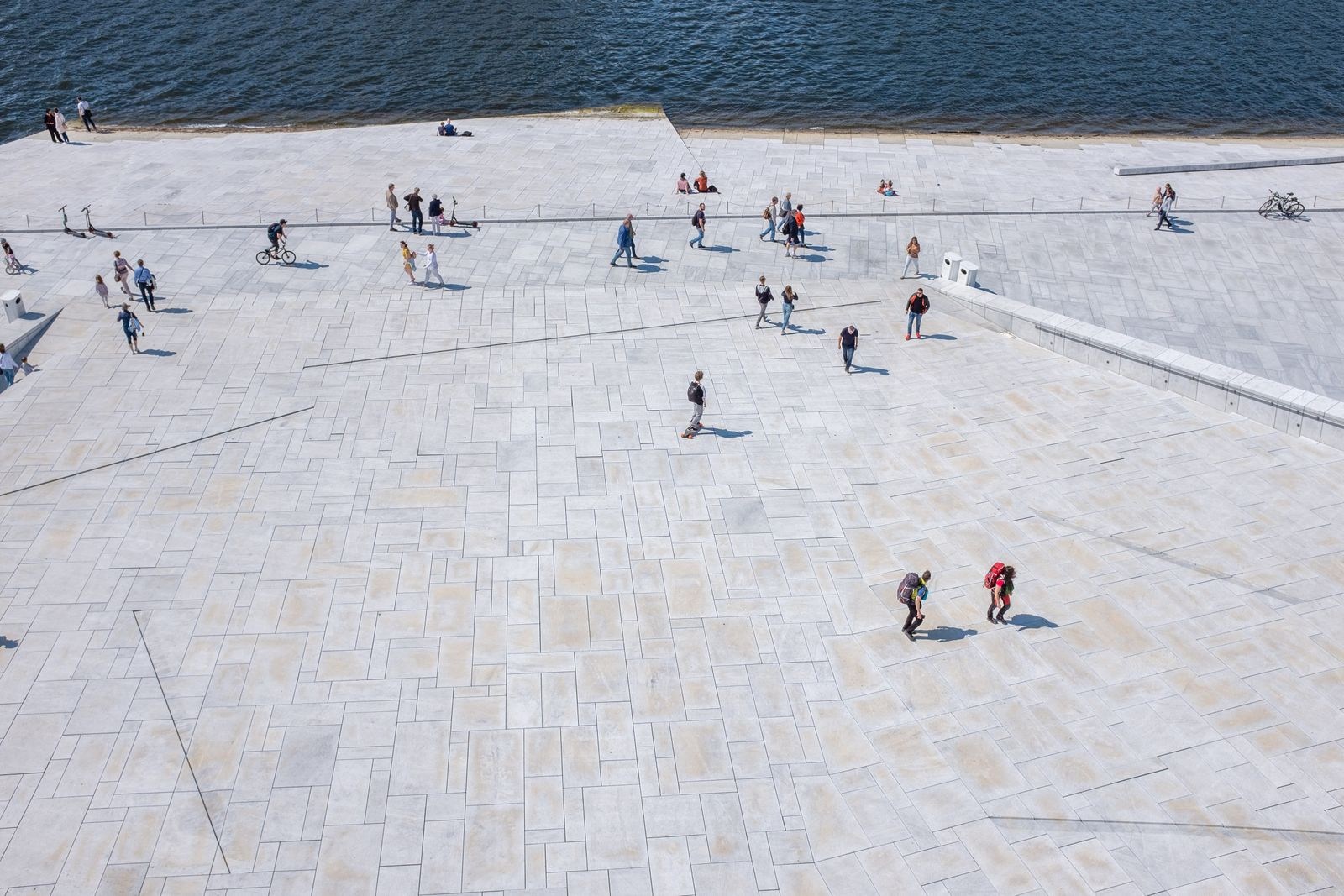 People on the broad waterfront surface at Oslo Opera House