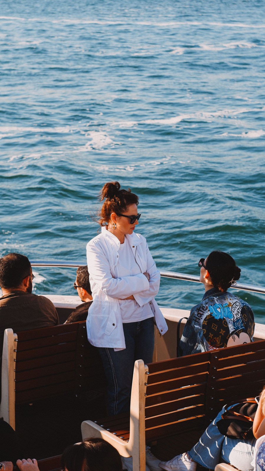 Passengers on ferry benches beside the water