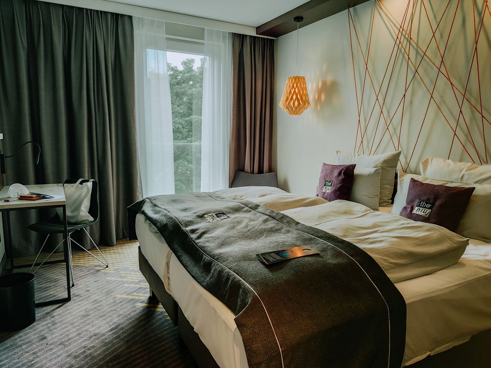 Hotel room with a bed, window and small work area