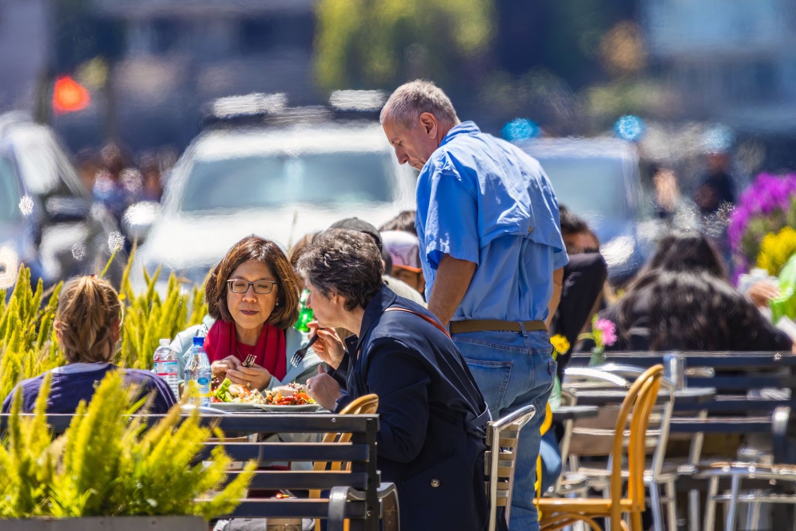 People eating at tables outside a cafe
