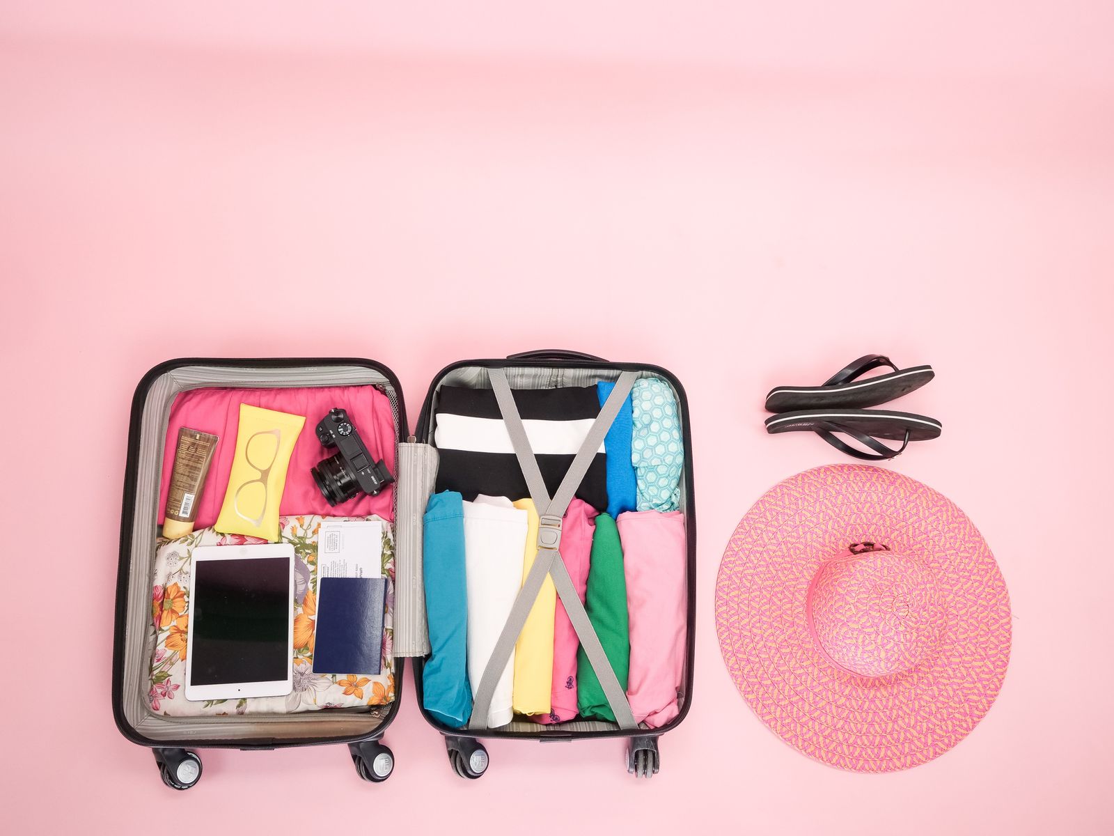 Open wheeled suitcase with clothing in both halves and internal compression straps