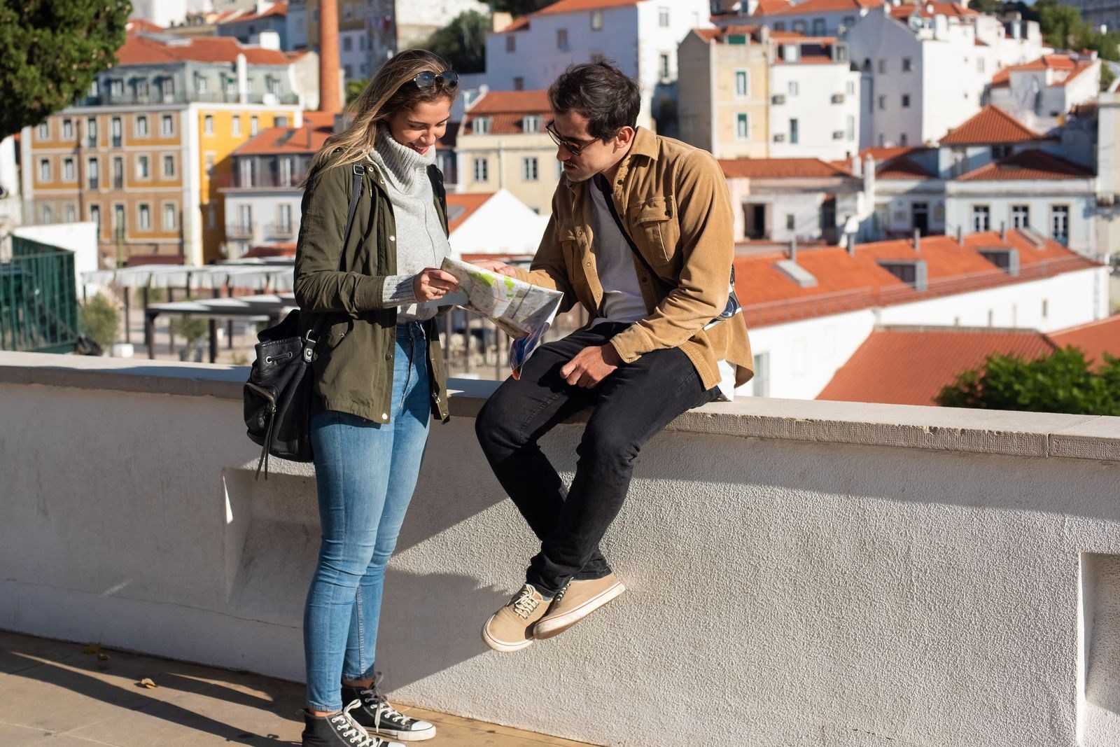Couple looking at a map together above city rooftops