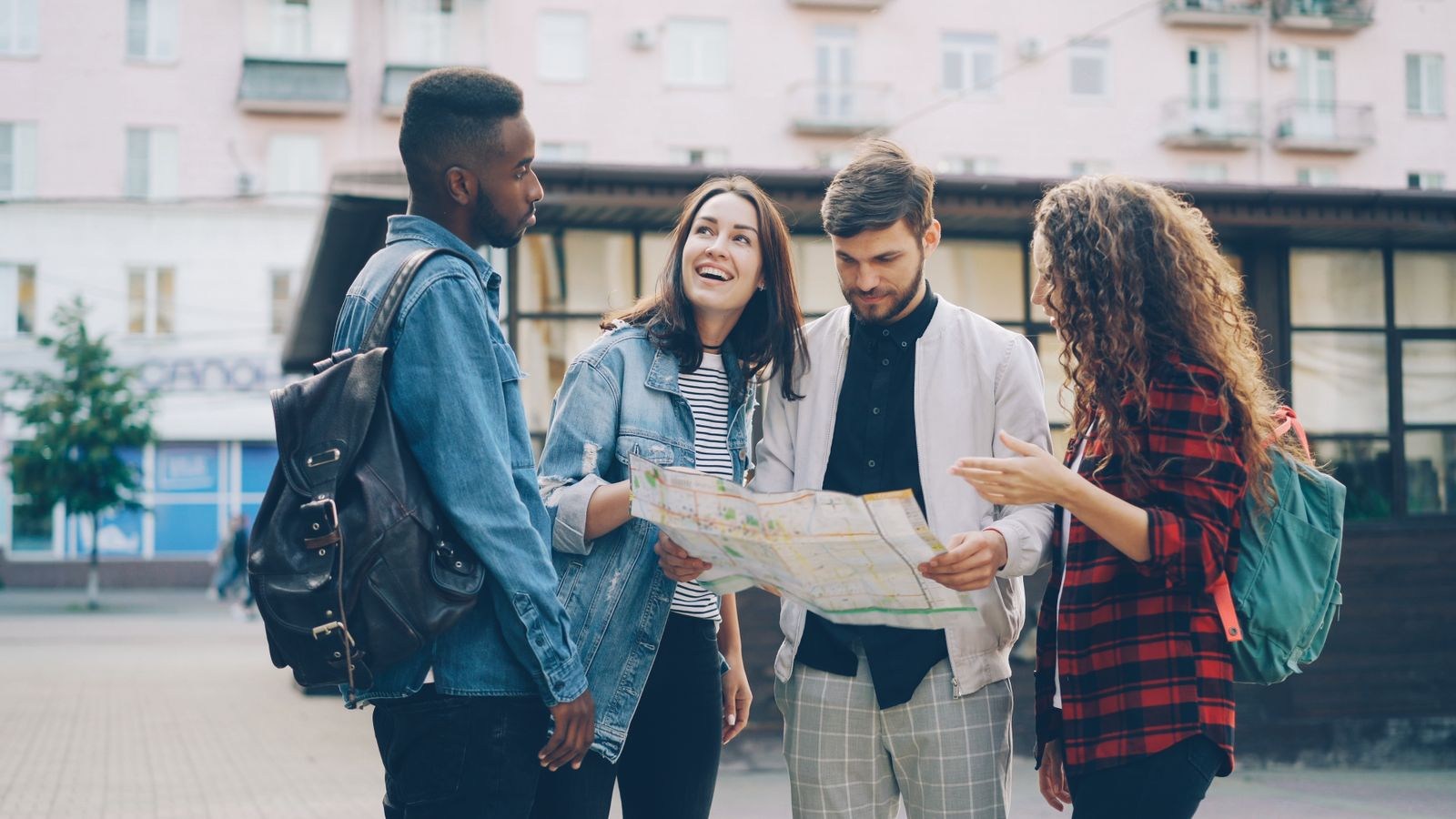 Group of friends discussing a map in a city square