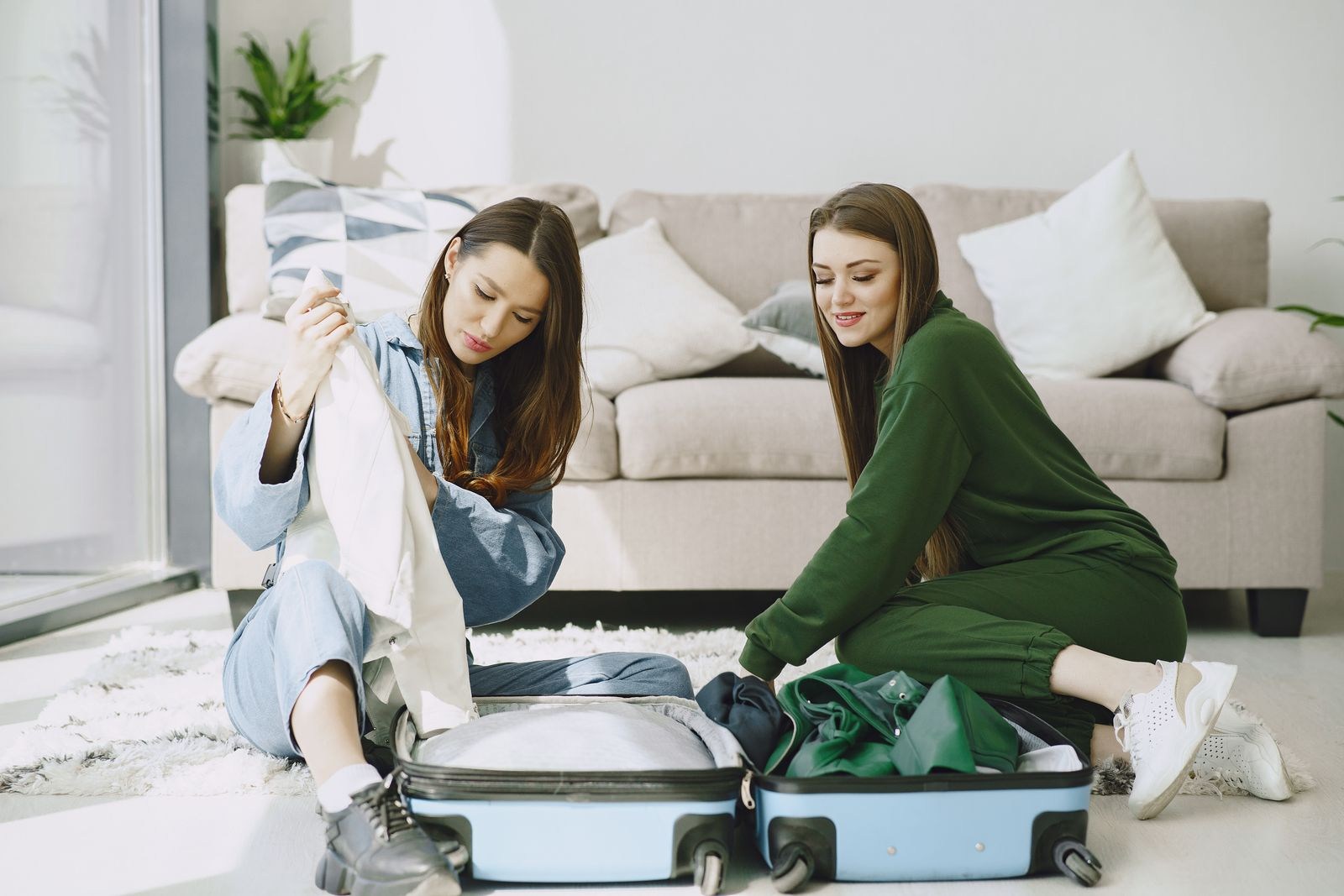 Two travelers unpacking a suitcase at their accommodation