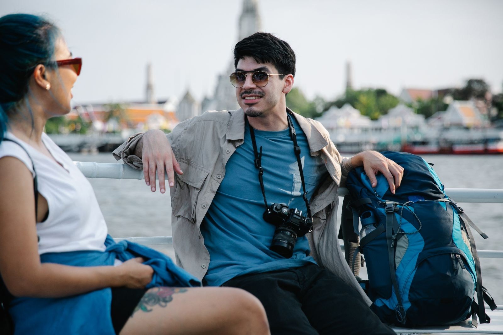 Two travelers resting with backpacks on a bench
